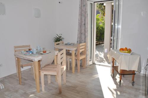 a dining room with tables and chairs and a sliding glass door at B&B Les Chambres Rooms & Suite in Santa Teresa Gallura