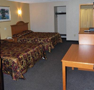 a hotel room with two beds and a table at South Bay Motel in Copiague
