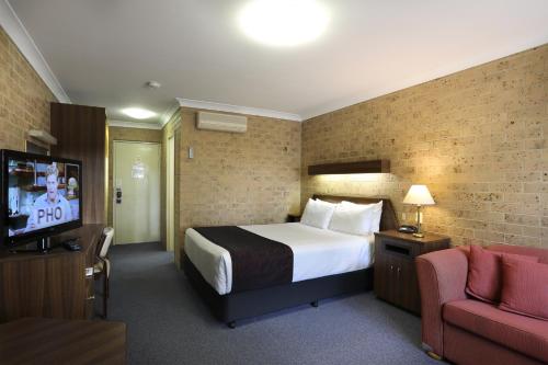 a hotel room with a bed and a tv at Tamworth Motor Inn & Cabins in Tamworth