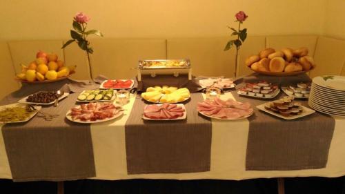 a table with plates of food and bowls of fruit at Hotel Friedrich in Hachenburg