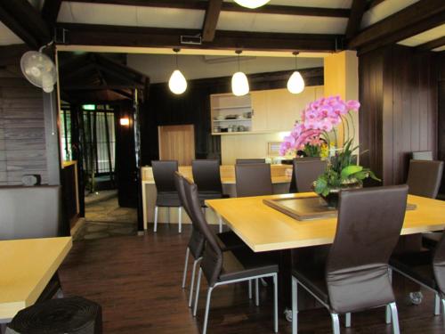a dining room with a table and chairs and flowers at KyuFun Komachi in Jiufen