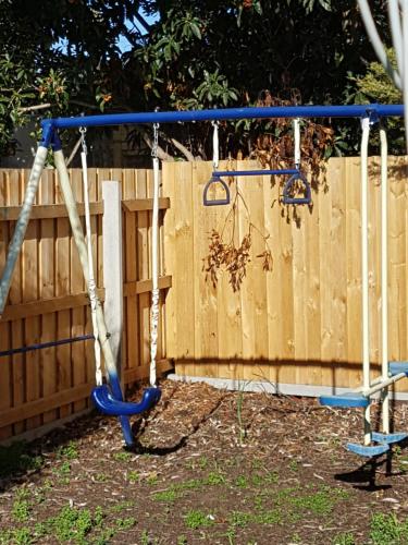 a blue swing in front of a wooden fence at Kings Cottage in Paynesville