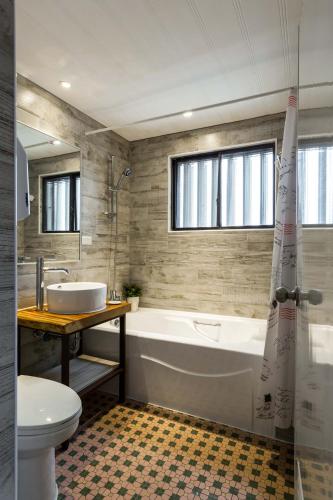 a bathroom with a tub and a sink and a toilet at 樂亞亞奇文旅 in Luodong