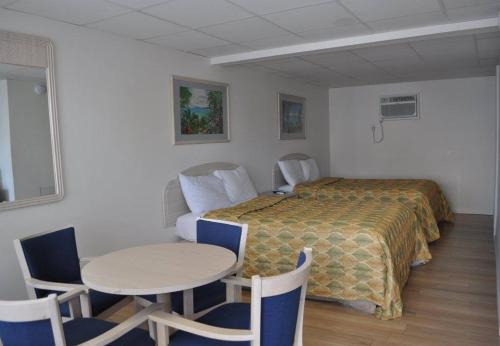 a hotel room with a bed and a table and chairs at Islander Motel in Ocean City