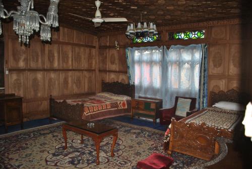a living room with two beds and a window at Kashmir View group of Houseboat in Srinagar
