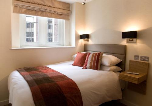 1 dormitorio con 1 cama grande y ventana en The Jade, en Londres