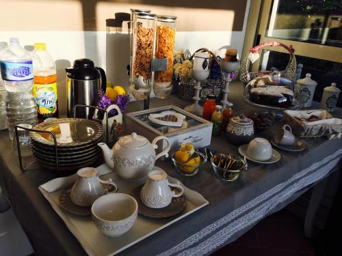 a table topped with dishes and cups and other items at Grotta dei Puntali B&B in Carini
