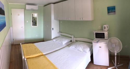 a hospital room with a bed and a microwave at Apartments Villa Stella Maris in Rogoznica