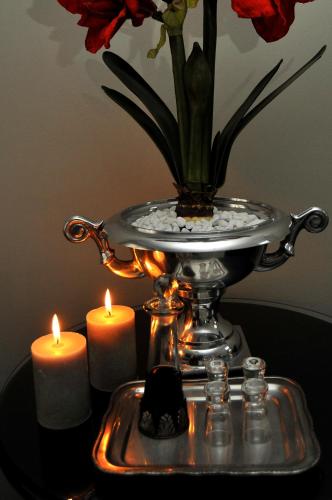 a tray with two candles and a vase with flowers at Adato Guesthouse in Potchefstroom