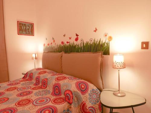 ein Schlafzimmer mit einem Bett mit einer farbenfrohen Tagesdecke in der Unterkunft Anna e Franco Home in Rom