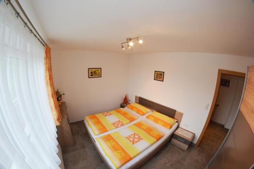 ティールゼーにあるHaus Panorama, Johanna Pfluger, Kirchdorf 56, A-6335 Thierseeのベッドルーム1室(オレンジと黄色のシーツを使用したベッド2台付)