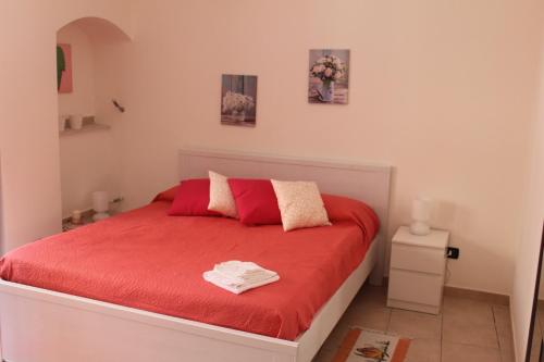 カターニアにあるA casa di Ettoreの赤いベッド1台、赤い枕2つが備わるベッドルーム1室が備わります。