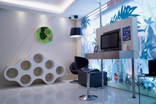 a living room with a tv and a table and chairs at CityInn Hotel Taipei Station Branch II in Taipei