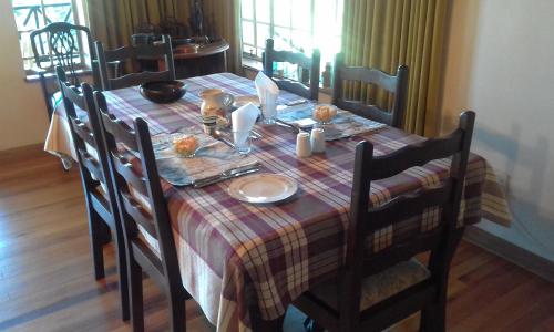 a dining room table with a checkered tablecloth andoverty at Thaba Tsweni Lodge & Safaris in Graskop