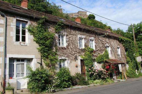 an old stone house with ivy growing on it at Hotel Restaurant Les Gorges de Chouvigny in Chouvigny