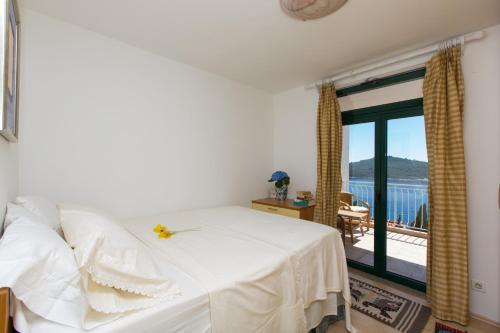 a bedroom with a white bed and a balcony at Ambassador Suite Dubrovnik in Dubrovnik
