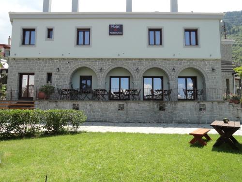 a large white building with windows and a yard at Hotel Rodovoli in Konitsa