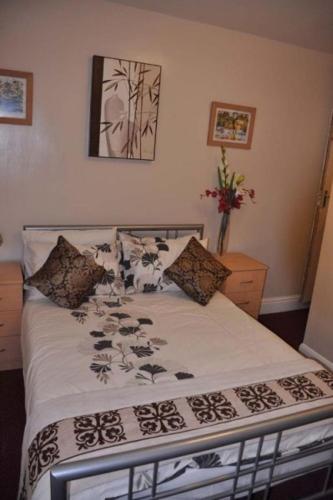 a bed with a black and white comforter on it at Braemer Guest House in Derby