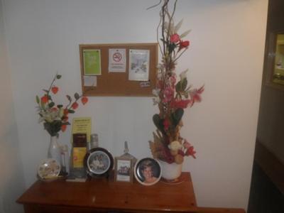 a wooden counter with flowers and clocks on it at Braemer Guest House in Derby