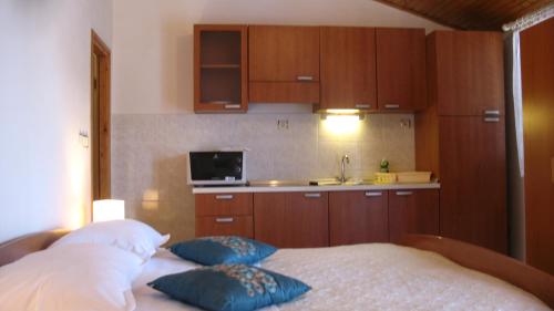 a bedroom with a bed with pillows and a kitchen at KrkaHaus in Lozovac