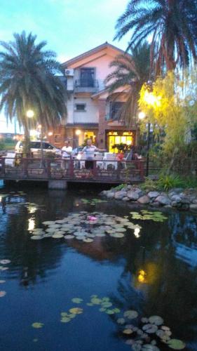a pond filled with lily pads in front of a building at Hua Qing Yuan in Yuanshan