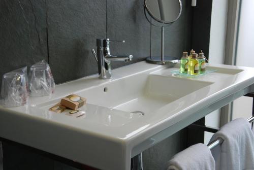 biała umywalka w łazience z lustrem w obiekcie Hotel de Naturaleza AV w mieście Ameixenda