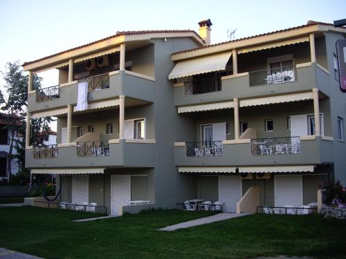 a large apartment building with a lawn in front of it at By the Sea Apartments-studios in Siviri