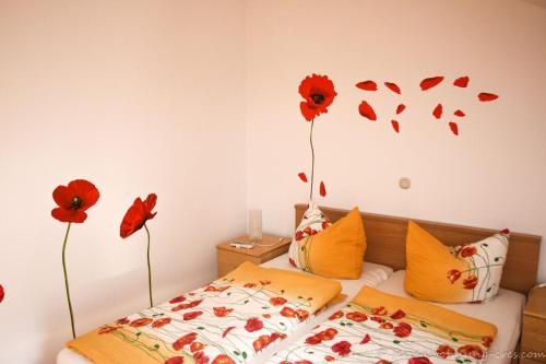 a bedroom with a bed with red flowers on the wall at Cres in Cres