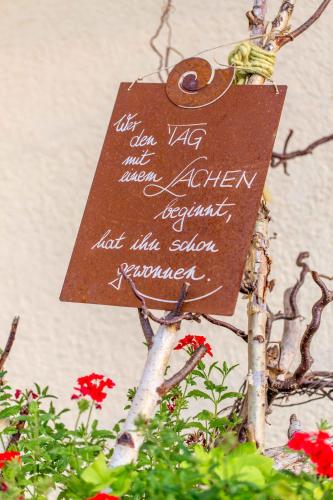 a sign on the side of a tree with flowers at Hotel Heselbacher Hof in Baiersbronn