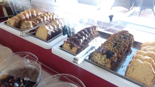 a display case with different types of cakes and pastries at Elektra Beach Hotel in Kalamaki Chanion
