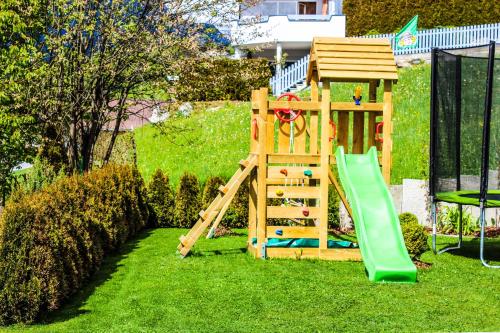 a wooden play set with a slide and a playground at Bergchalet Rauch in Arzl im Pitztal