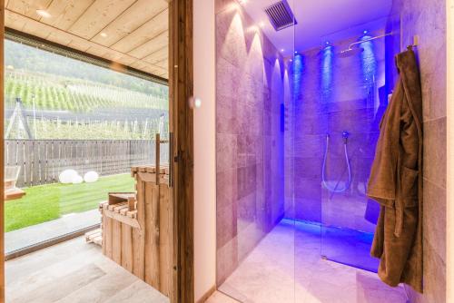 a purple bathroom with a shower and a glass door at Hotel Restaurant Kirchsteiger in Vollan
