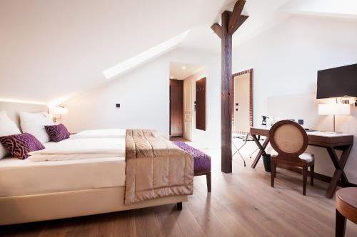 ein Hotelzimmer mit einem Bett und einem Schreibtisch in der Unterkunft Boutique Hotel Adria in Wels