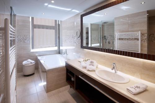 Boutique Hotel Adria في فيلس: حمام مع حوض وحوض ومرآة