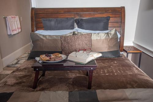 a table with a plate of food on a bed at Naomi's Inn Bed & Breakfast in Springfield