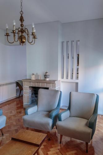 a living room with two chairs and a fireplace at Family Espinho Porto Guesthouse in Espinho