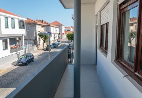 a balcony of a building with a car on the street at Family Espinho Porto Guesthouse in Espinho