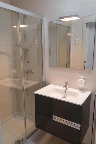 a bathroom with a sink and a shower at Family Espinho Porto Guesthouse in Espinho