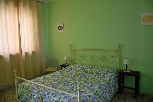 1 dormitorio con 1 cama y paredes verdes en B&B Maria Montis, en Assemini
