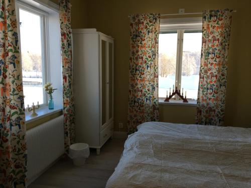 a bedroom with a bed and two windows at Orsa Station Bed and Breakfast in Orsa