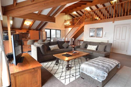 a living room with couches and a table at Hotel Pension Grimus in Mount Buller