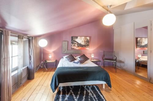 サントにあるSaveurs De l'Abbayeの紫の壁のベッドルーム1室、ベッド1台、テーブル2台が備わります。