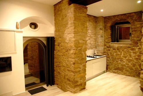 eine Küche mit einer Steinmauer und einer Theke in der Unterkunft Kaaba - Aragon home holiday in Montalbano Elicona