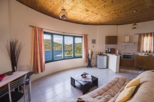 a large living room with a couch and a kitchen at Razos Windmill in Vathi