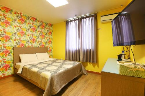 a bedroom with a bed and a tv in it at Su Motel in Buyeo