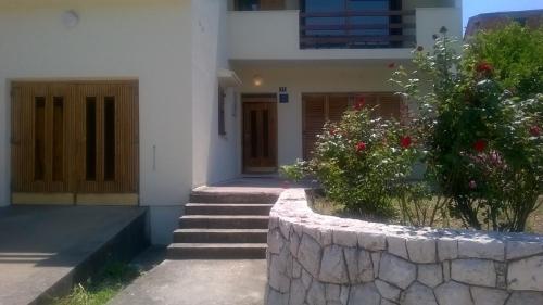 a building with a stone wall with stairs and flowers at Six bedroom Holiday home Matea in Ploče