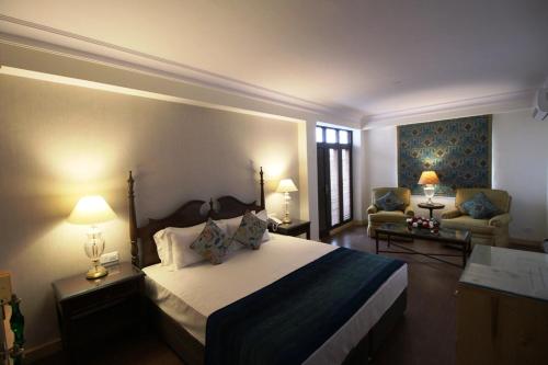 a bedroom with a large bed and a living room at The Oaktree House in Shimla
