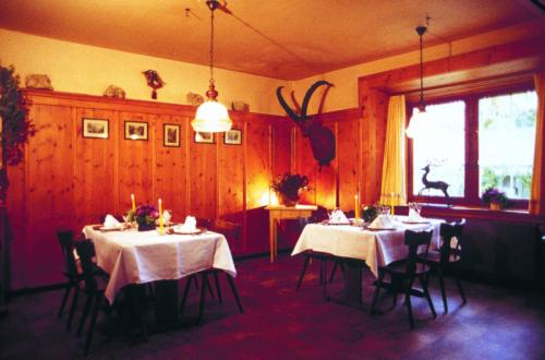 a dining room with two tables with white table cloth at Gasthaus Alte Post in Zillis