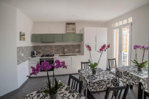 a kitchen with two tables with purple flowers on them at Guest House Vignola in Rome