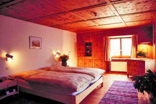 ein Schlafzimmer mit einem großen Bett und einer Holzdecke in der Unterkunft Gasthaus Alte Post in Zillis